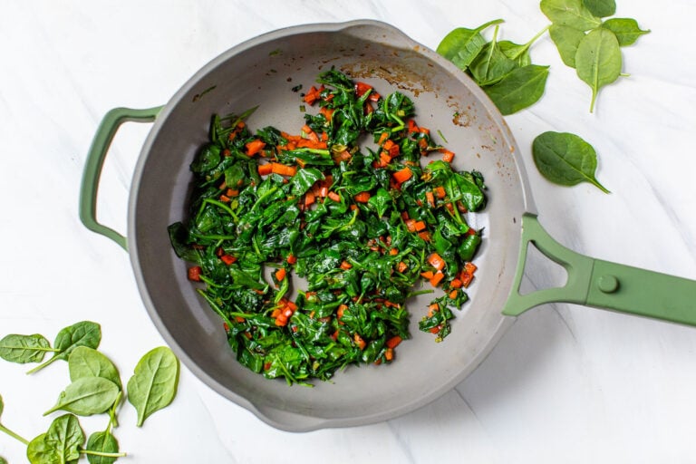 A skillet with greens and veggies