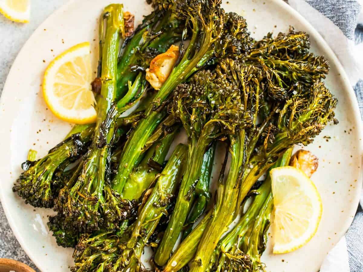 A plate of roasted broccolini with lemons