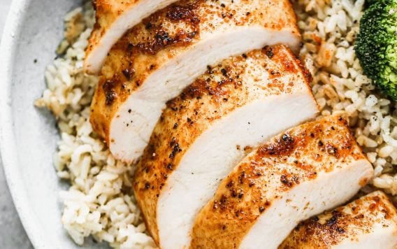A sliced oven roasted chicken breast that looks juicy and well seasoned