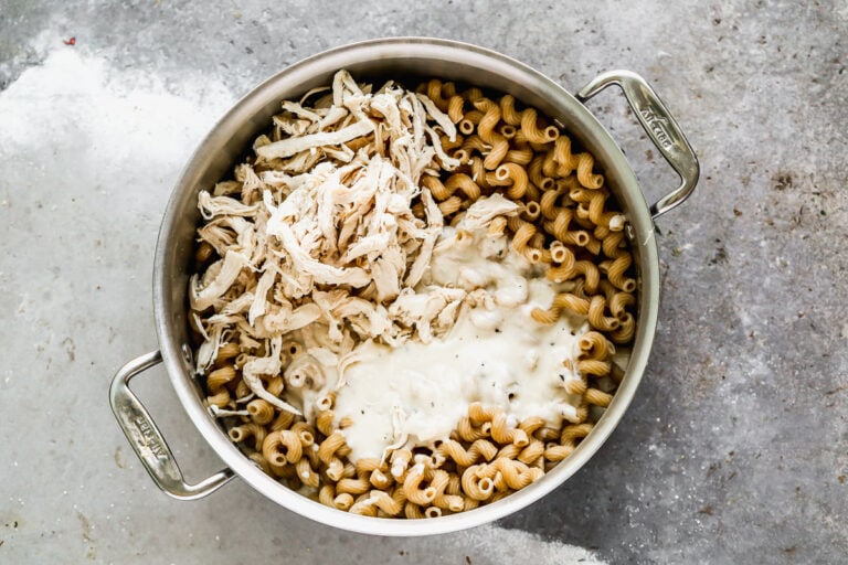 Chicken and sauce being added to pasta