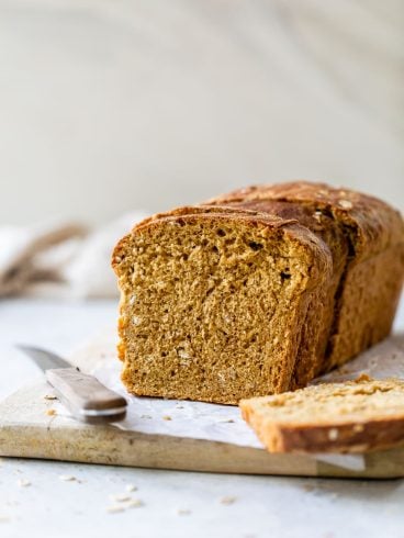 a loaf of fluffy homemade oatmeal bread cut into slices
