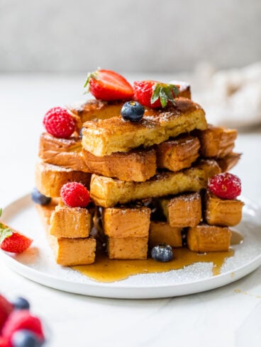 oven baked french toast sticks on a plate with powdered sugar