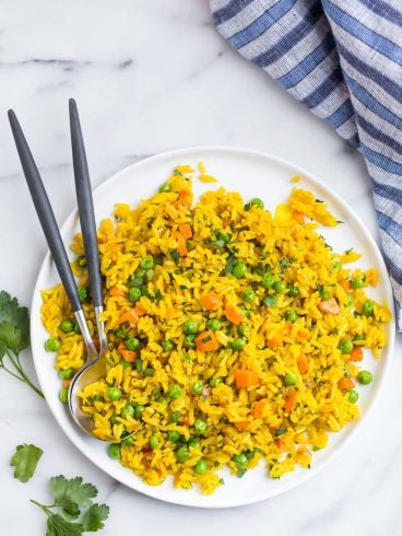 Simple turmeric rice on a plate with two spoons