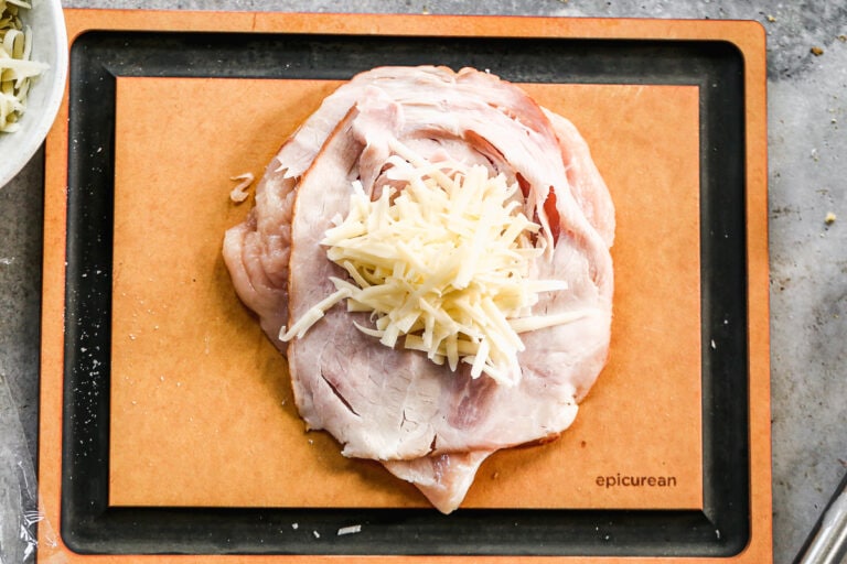 A ham slice and cheese on top of meat