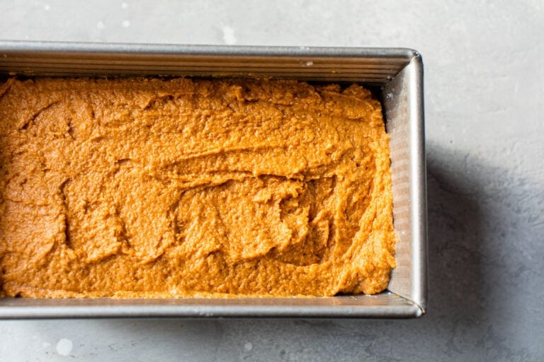pumpkin bread batter made with whole wheat flour spread into a loaf pan