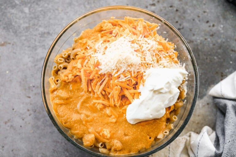 Stirring cheese, Greek yogurt, and pumpkin sauce into cooked pasta for pumpkin mac and cheese