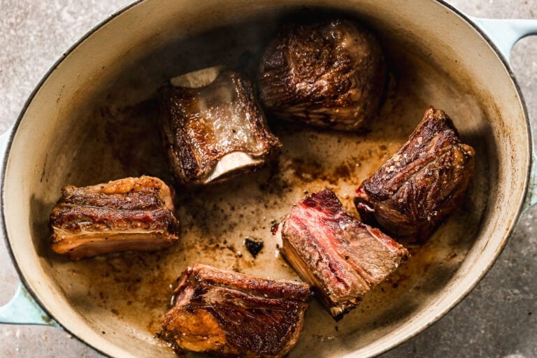 Short ribs being browned in a Dutch oven