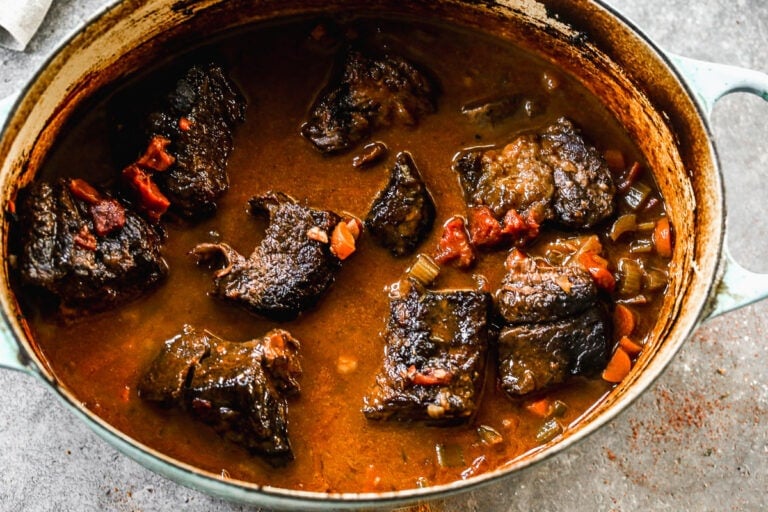 A dutch oven with meat in a sauce