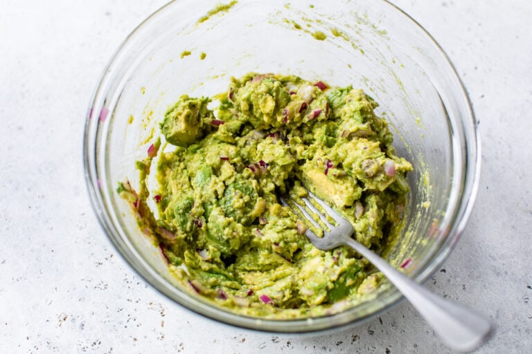 Simple homemade guac being mashed in a bowl