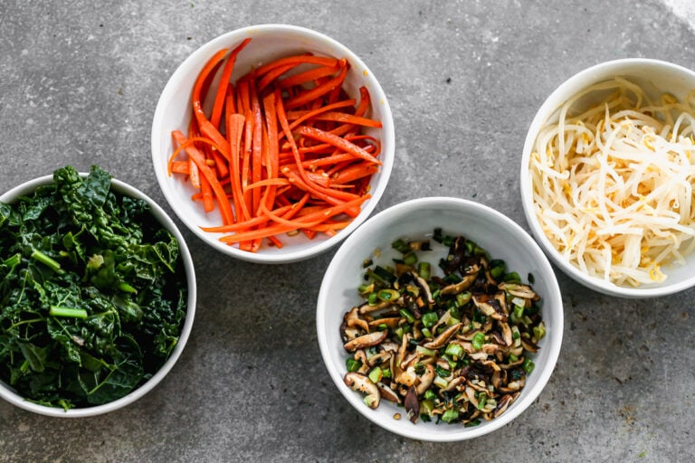 four bowls filled with healthy vegetarian bibimbap ingredients