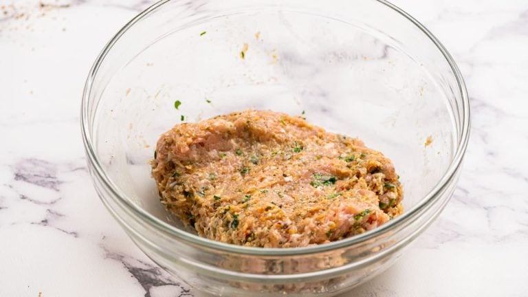 a bowl with ground turkey mixed with herbs and seasonings