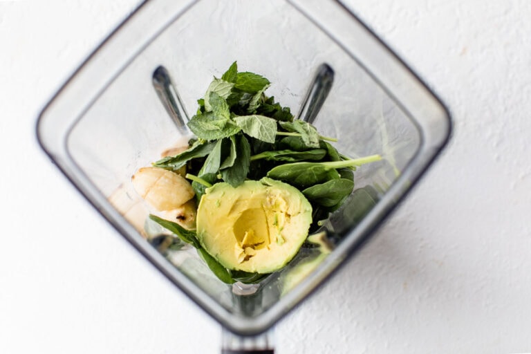 Spinach, avocado, bananas, and mint in a blender