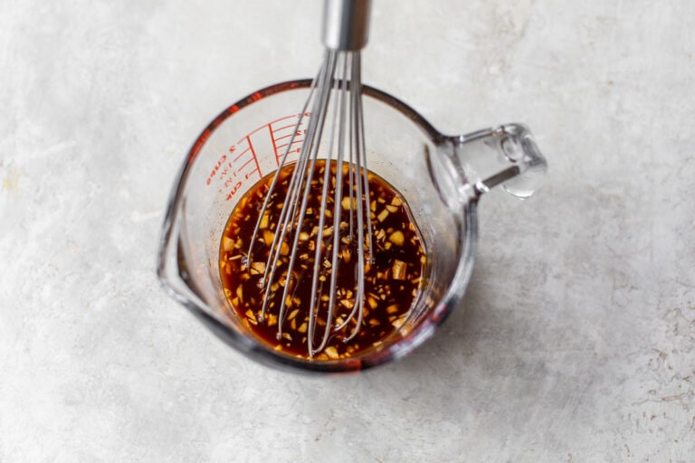 A sauce being whisked in a measuring cup