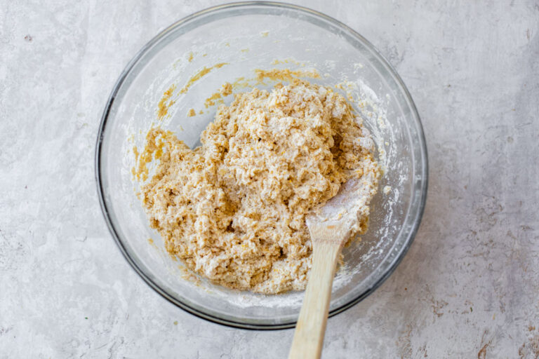 a glass mixing bowl of southern cornbread muffin batter with applesauce