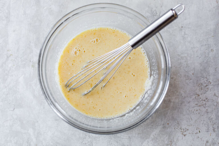 a mixing bowl of wet ingredients whisked together for cornbread muffins