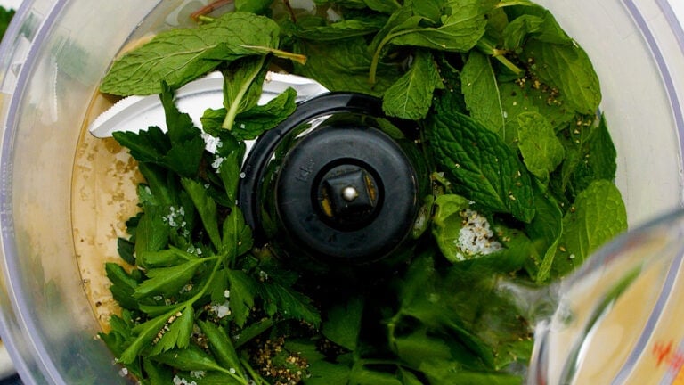 a quick and easy tahini dressing being pulsed in a food processor for buddha bowls