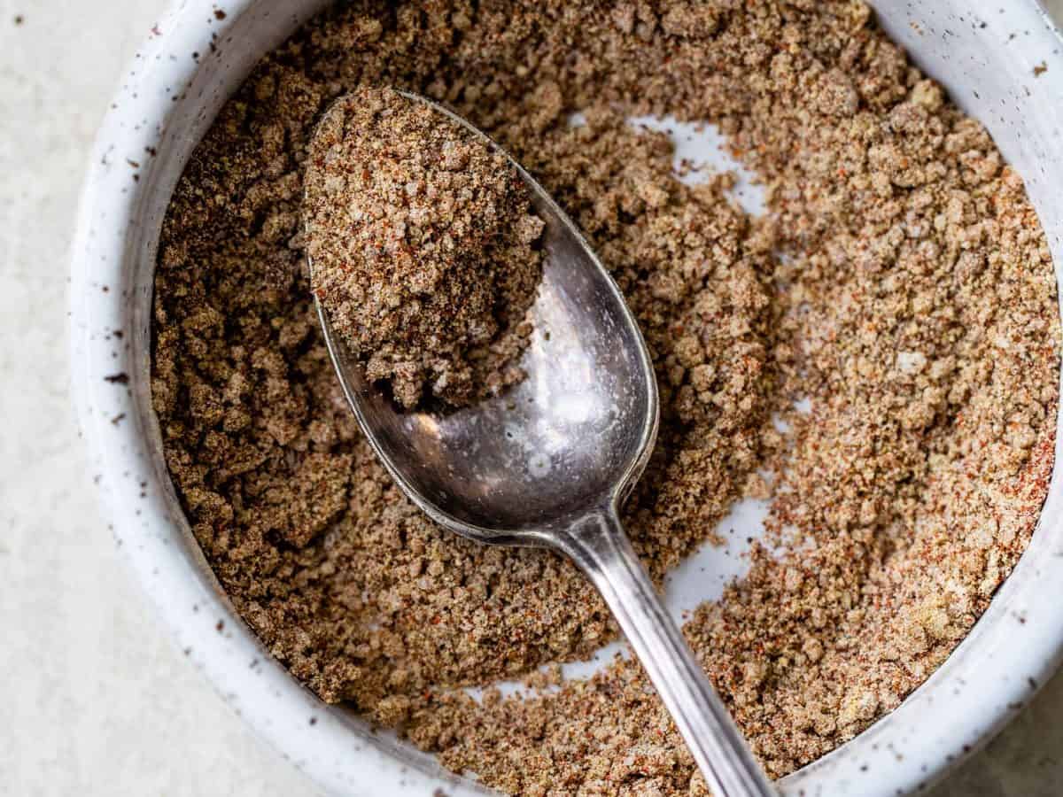 A bowl full of spices with a spoon