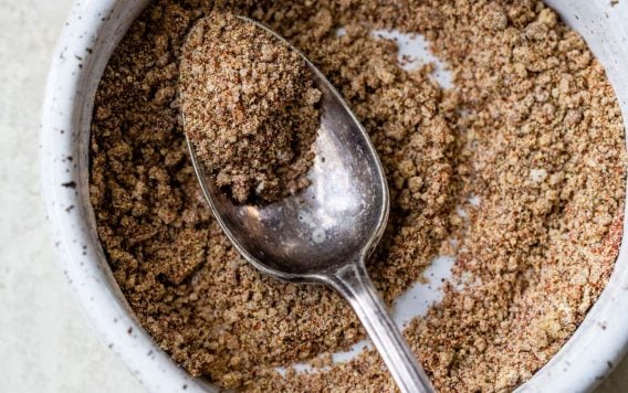 A bowl full of spices with a spoon