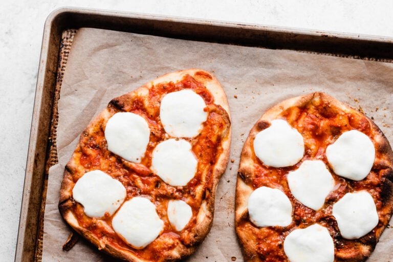 Two delicious naan pizzas with cheese