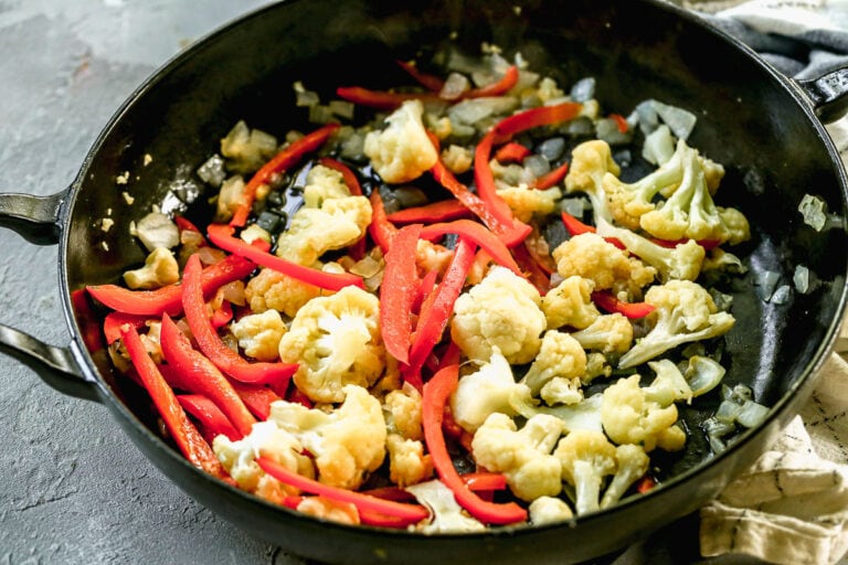 a skillet of sautéed cauliflower and bell peppers