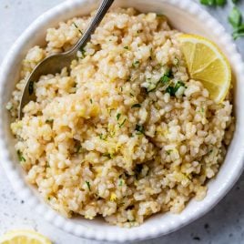 A spoon and bowl of the Best lemon rice recipe with parsley