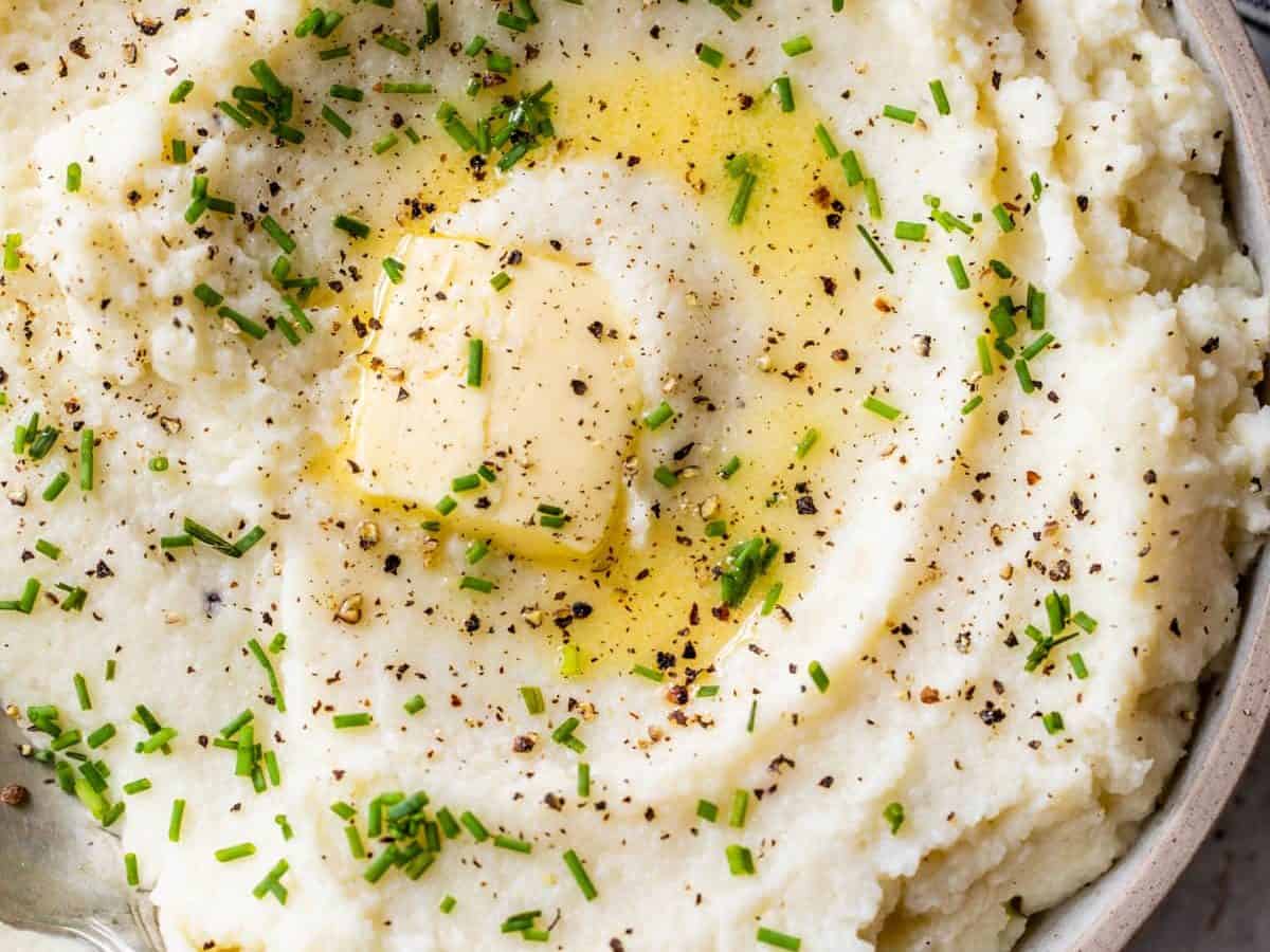 Cauliflower mashed potatoes in a bowl with chives and butter