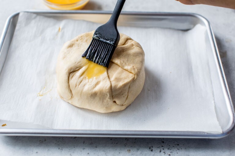Egg wash being brushed over the top of dough