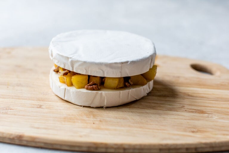 Two slices of brie with apples and pecans in between