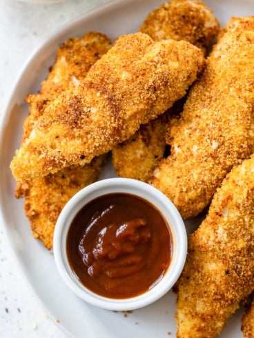 a plate of crispy air fryer chicken tenders with dipping sauce