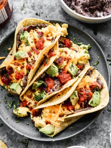 three easy breakfast tacos with toppings on a plate