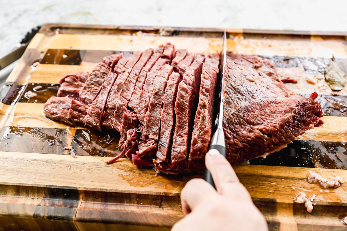 slicing classic corned beef recipe on cutting board
