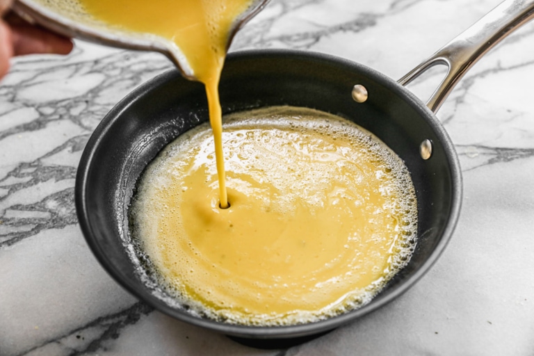 pouring eggs into pan for french omelette