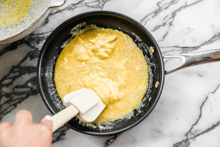 cooking eggs in a pan for a how to make a french omelette