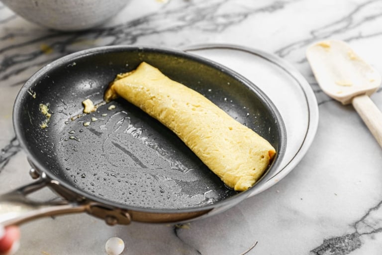 seam side down french omelette sliding off a pan