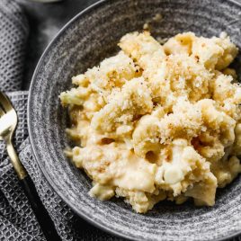 cauliflower mac and cheese in a bowl with breading