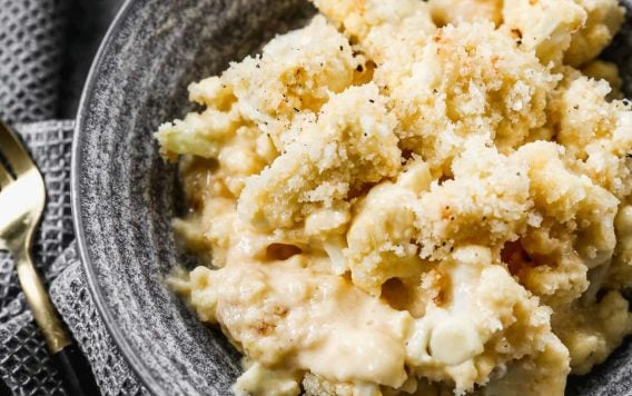 cauliflower mac and cheese in a bowl with breading