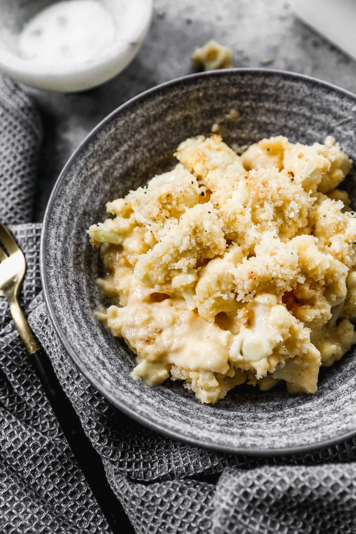 cauliflower mac and cheese in a bowl with breading