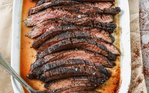 flank steak marinated and grilled on a large plate