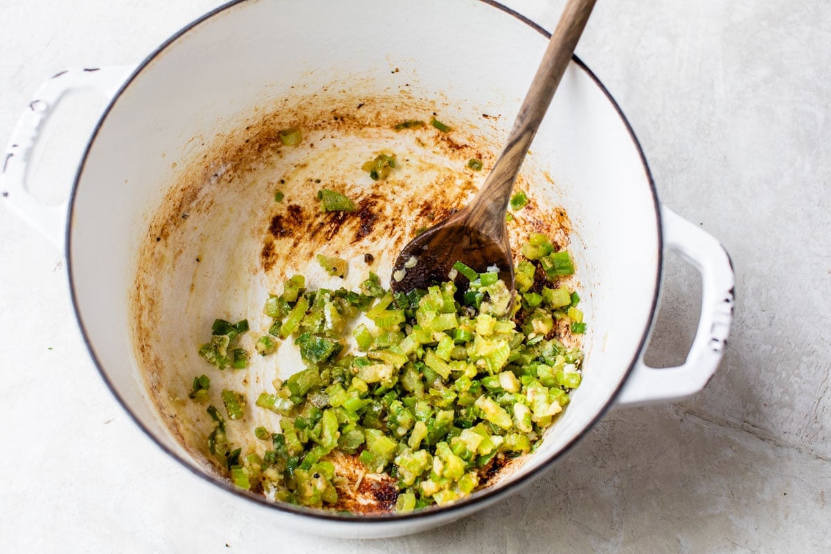 sauteed vegetables in a pot for creamy corn chowder