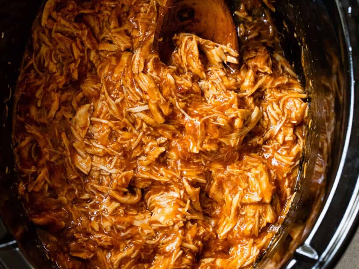 Crockpot BBQ chicken with wooden spoon