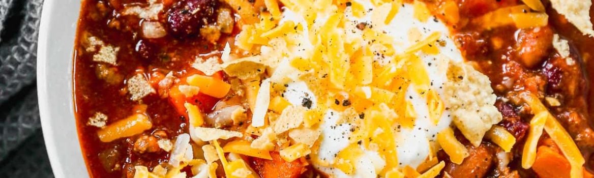 Instant Pot chili in bowl topped with sour cream and cheese