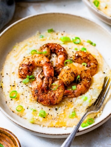 new orleans shrimp and grits in a bowl with a fork