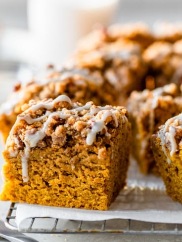a slice of moist pumpkin coffee cake with streusel crumb topping and glaze