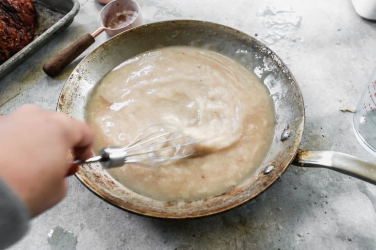 whisking gravy on a skillet for ham