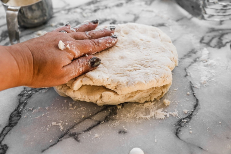 rolling out biscuit dough for flaky biscuits