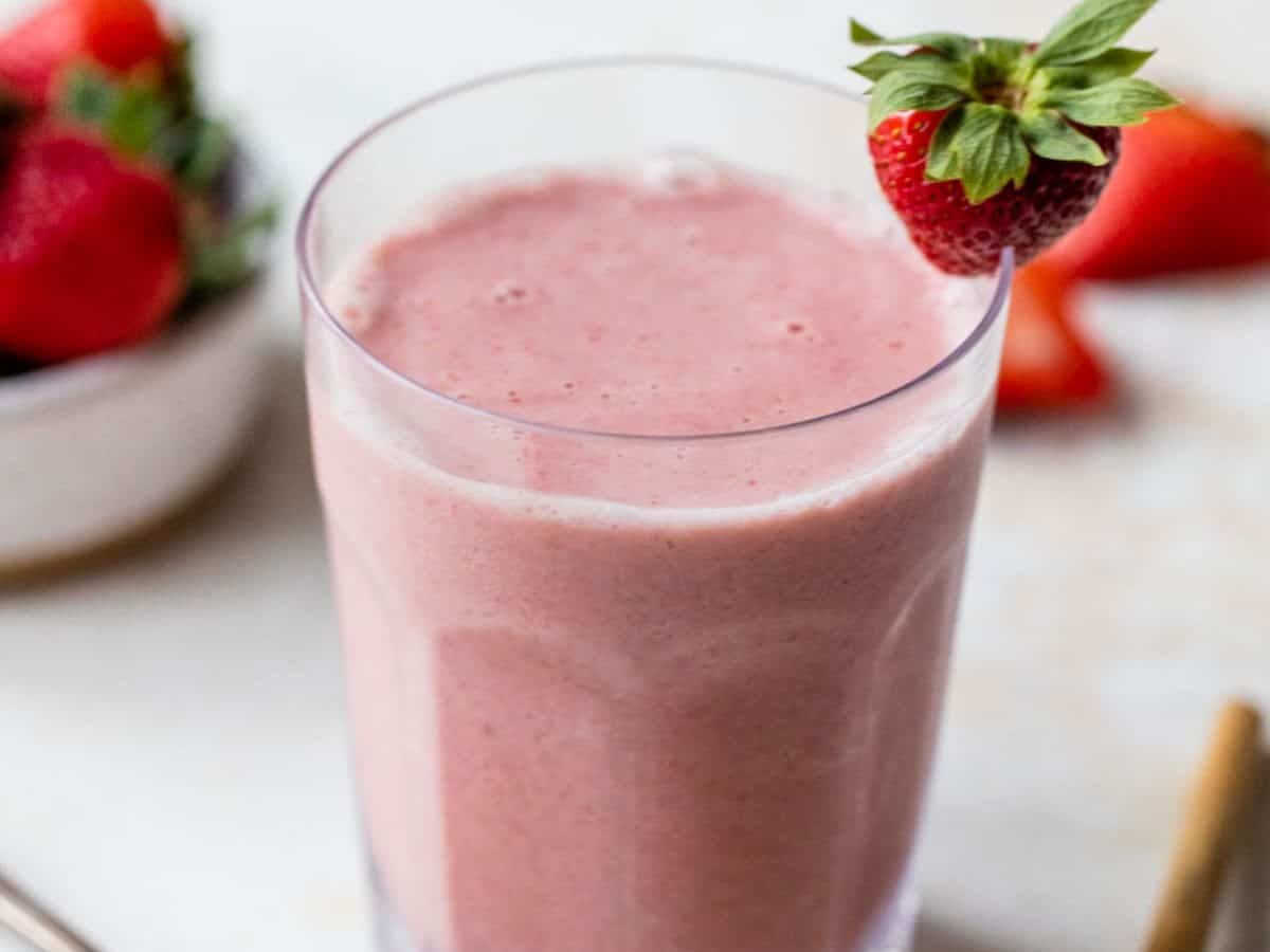 the BEST strawberry smoothie recipe EVER in a glass with strawberries