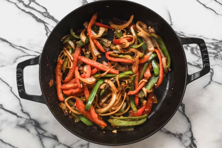 Peppers and onions cooking in skillet