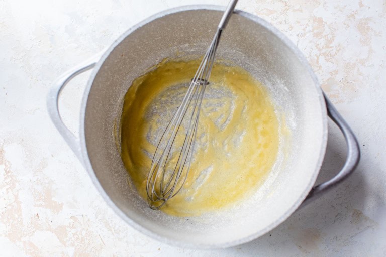 Butter and flour in pot with whisk