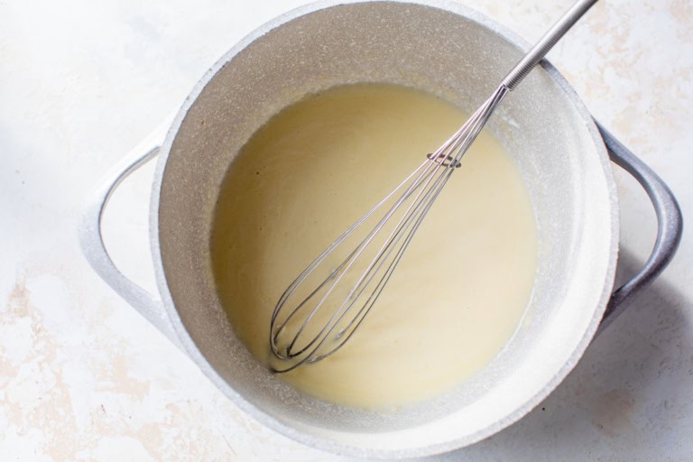 Roux for cheese sauce in pot with whisk