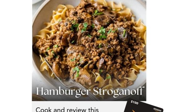 A plate of hamburger stroganoff over noodles with text about a March cooking challenge to win a $100 Amazon gift card.